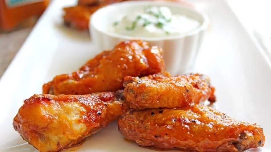 Grilled Garlic Buffalo Wings next to Yogurt Sauce