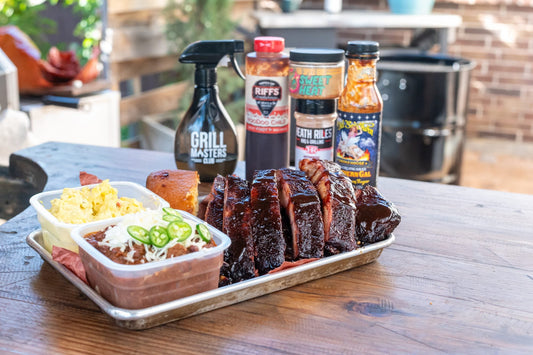 Sauced smoked ribs with sides and Grill Masters Club BBQ sauces and rubs