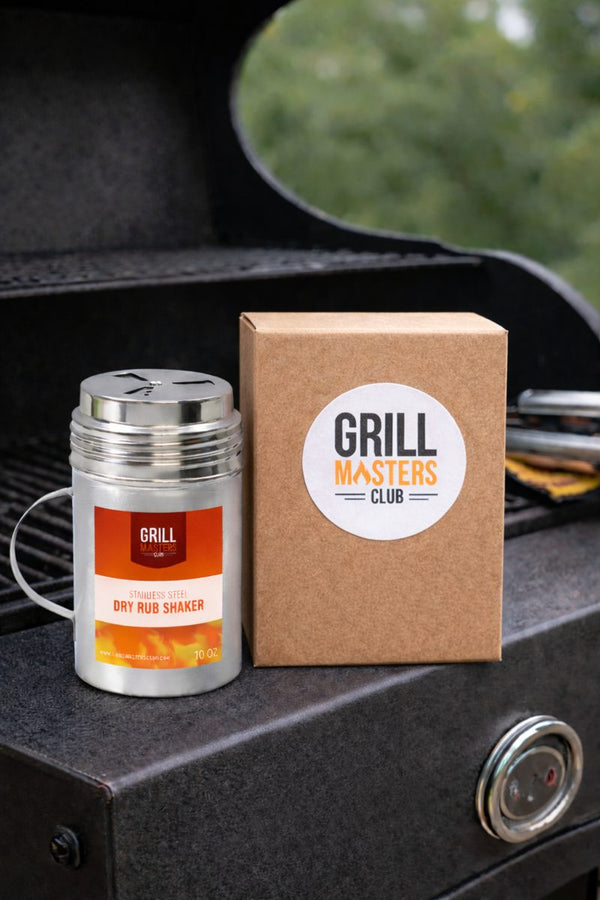 Grill Masters Club 10 oz stainless steel dry rub shaker beside a Grill Masters Club box on a grill