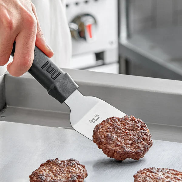 A hand flips a mini burger using the 9 inch stainless steel mini grill spatula